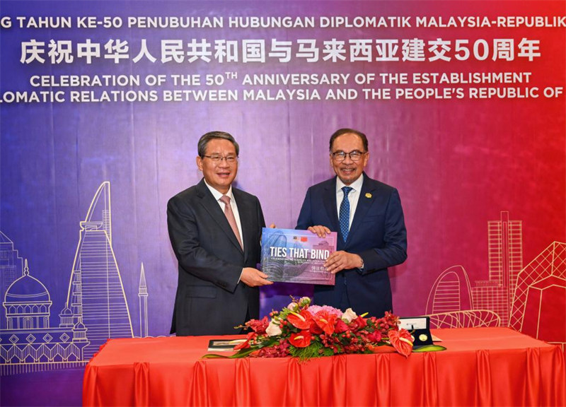 Waziri Mkuu wa China Li Qiang na Waziri Mkuu wa Malaysia Anwar Ibrahim wakipeana zawadi za ukumbusho kabla ya tafrija ya maadhimisho ya miaka 50 tangu kuanzishwa kwa uhusiano wa kidiplomasia kati ya China na Malaysia na Mwaka wa Urafiki wa China na Malaysia mjini Kuala Lumpur, Malaysia, Juni 19. 2024. (Xinhua/Rao Aimin)