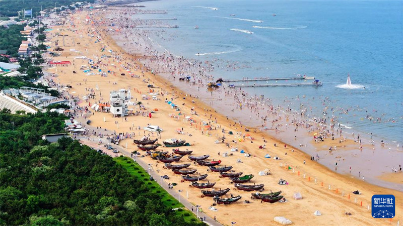 Kwenda ufukweni kuepuka joto kali kwavutia watu wengi katika Mji wa Rizhao, Mkoani Shandong, China
