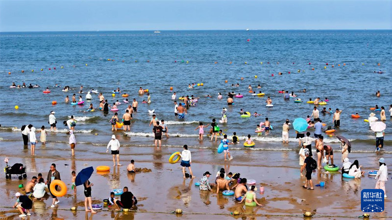 Kwenda ufukweni kuepuka joto kali kwavutia watu wengi katika Mji wa Rizhao, Mkoani Shandong, China