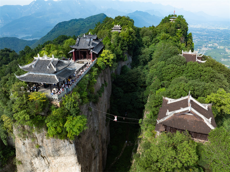 Kutazama maonyesho ya watembea angani kwenye mnyororo wa chuma ulioko kati ya vilele viwili virefu vya Mlima Douqi, Mkoani Sichuan, China