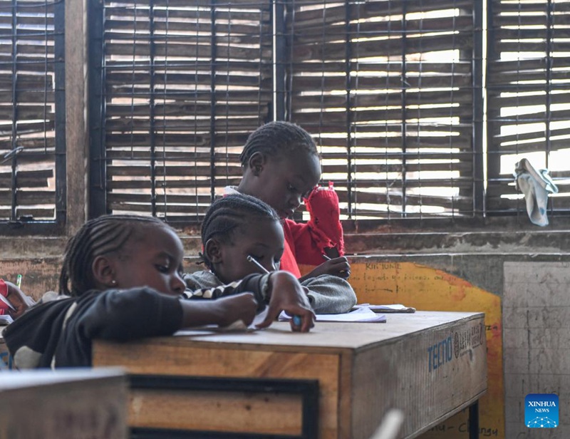 Wanafunzi wakifanya kazi za masomo kwenye madawati mapya yaliyochangiwa shuleni katika mitaa ya mabanda ya Mathare jijini Nairobi, Kenya, Oktoba 15, 2024. (Xinhua/Li Yahui)