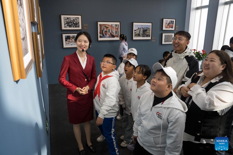 Mfanyakazi akitoa maelezo kuhusu picha kwa wanafunzi na walimu kwenye maonyesho ya picha yaliyofanyika katika Kituo cha kitaifa cha Taarifa za Mambo ya Fedha cha China mjini Beijing, Oktoba 30, 2024. (Xinhua/Cai Yang)