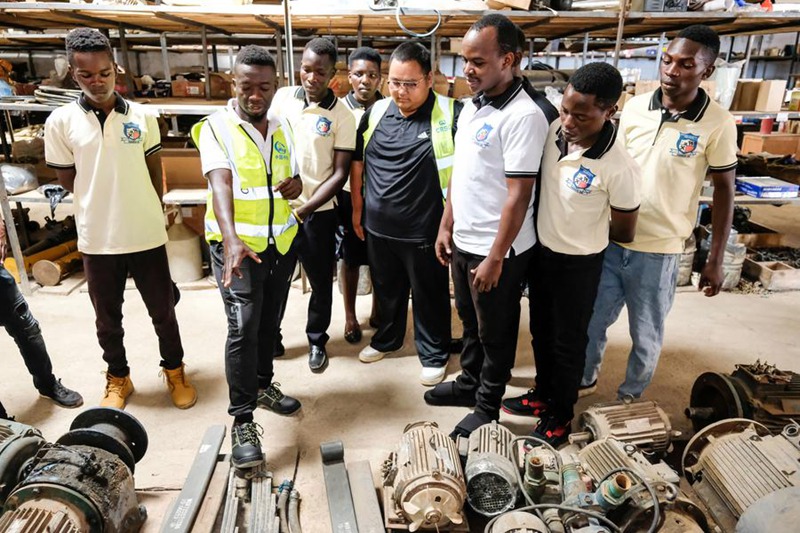 Tarehe 28, Oktoba, wanafunzi wa Chuo cha Teknolojia cha Buhimba wakitembelea  ghala ya kambi ya ujenzi wa barabara ya China huko Kikuube, Magharibi mwa Uganda. (Picha na Hajarah Nalwadda/Xinhua)