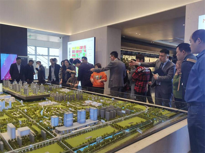Picha hii ikionyesha watu wakitazama meza ya mchanga ya mfano wa mradi wa nyumba mjini Shanghai, mashariki mwa China, Mei 28, 2024. (Xinhua/Zheng Juntian)