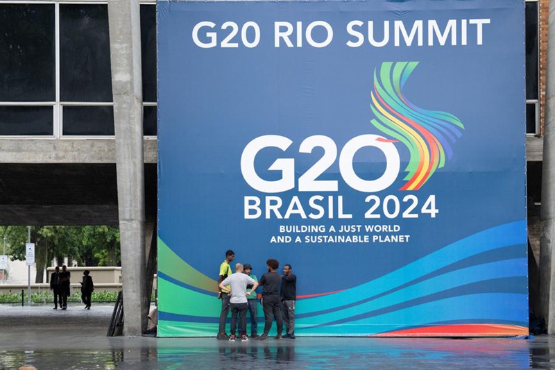 Wafanyakazi wakiwa wamekusanyika karibu na bango katika eneo la mkutano wa G20  huko Rio de Janeiro, Brazili, Novemba 16, 2024. (Xinhua/Wang Tiancong)