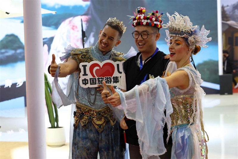 Mtu (katikati) akipiga picha kwenye banda la Kundi la Utalii la China kwenye shughuli ya Kimataifa ya Utalii ya China Mwaka 2024 mjini Shanghai, Mashariki mwa China, Novemba 22, 2024. (Xinhua/Fang Zhe)