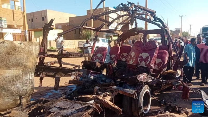 Watu wakiwa wamekusanyika karibu na basi la abiria lililobomolewa  katika shambulio la vikosi vya wanamgambo Mjini Omdurman, Sudan, Desemba. 10, 2024. (Ofisi ya Habari ya Serikali ya Sudan ya Khartoum/kupitia Xinhua)