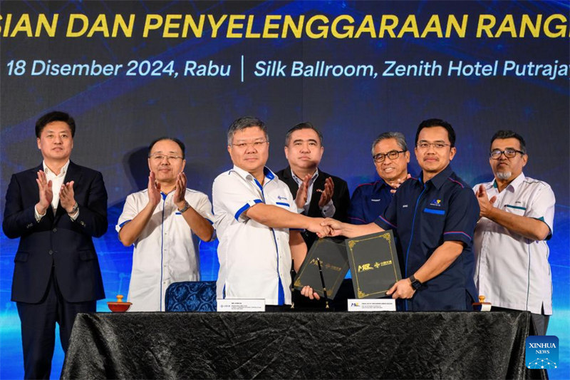Waziri wa Uchukuzi wa Malaysia Anthony Loke Siew Fook (katikati) na Balozi wa China nchini Malaysia Ouyang Yujing (wa pili kulia) wakihudhuria hafla ya kutia saini makubaliano ya ubia kati ya Kampuni ya Ujenzi wa Mawasiliano ya China (CCCC) na Kampuni ya reli ya Malaysia (MRL) mjini Putrajaya, Malaysia, Desemba 18, 2024. (Picha na Chong Voon Chung/Xinhua)