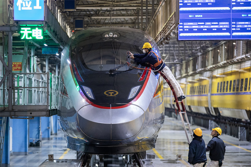 Mafundi wakishughulikia tatizo la vifutio vya kioo cha mbele cha treni ya mwendokasi ya Fuxing katika karakana ya EMU ya Shirika la Kundi la Kampuni za Reli la China, Tawi la Xi’an, mjini Xi’an, Shaanxi, Januari 7, 2025. (Picha kutoka vip.people.com.cn)