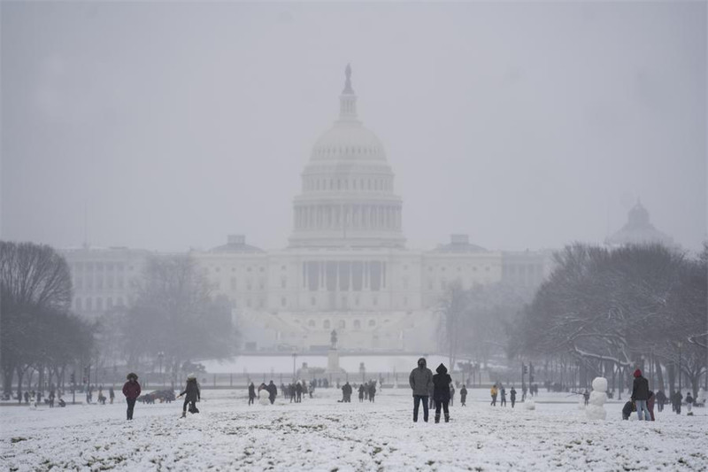 Watu wakicheza kwenye theluji mbele ya Jumba la Taifa karibu na jengo la Bunge la Marekani, Capitol Hill mjini Washington D.C., Marekani, Januari 31, 2021. (Xinhua/Liu Jie)