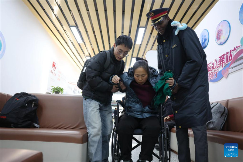 Mwanafunzi wa kujitolea Kalbe Brai Madoue kutoka Chad akimsaidia abiria kwenye ukumbi wa kusubiria treni wa Stesheni ya Reli ya Lanzhou Magharibi katika Mkoa wa Gansu, kaskazini-magharibi mwa China, Januari 18, 2025. (Xinhua/Chen Bin)