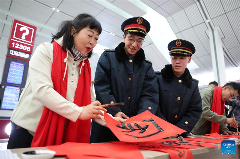 Wanafunzi wa kigeni wawa watu wa kujitolea wa Stesheni ya Treni ya Lanzhou katika pilika za kuwahudumia wasifiri wakati wa Mwaka Mpya wa Jadi wa China
