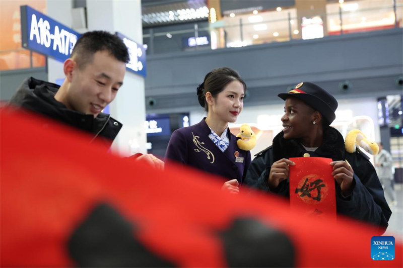 Wanafunzi wa kigeni wawa watu wa kujitolea wa Stesheni ya Treni ya Lanzhou katika pilika za kuwahudumia wasifiri wakati wa Mwaka Mpya wa Jadi wa China