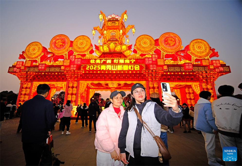 Watu wakijipiga picha mbele ya mapambo yenye mwanga wenye kung’aa mjini Nanning, mji mkuu wa Mkoa unaojiendesha wa Kabila la Wazhuang wa Guangxi, kusini mwa China, Januari 18, 2025. (Xinhua/Zhou Hua)