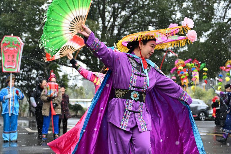 Wasanii wa michezo ya sanaa ya kijadi ya Lichuan Dengge wakifanya maonesho mtaani katika Wilaya ya Baiyangba ya Mji wa Lichuan, Eneo linalojiendesha la Watujia na Wamiao la Enshi, Mkoa wa Hubei, katikati mwa China, Februari 6, 2025. (Xinhua/Du Zixuan)