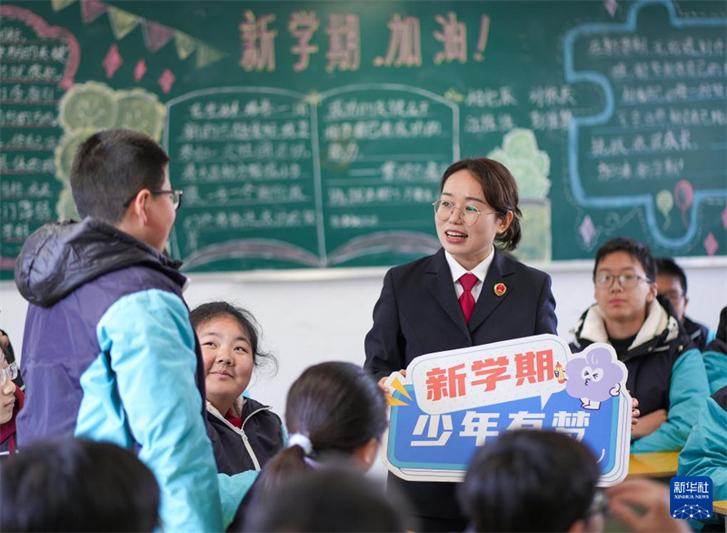 Mfanyakazi wa Idara ya Uendeshaji Mashtaka ya Mji wa Xinghua, Mkoa wa Jiangsu akifahamisha ujuzi wa sheria kwa wanafunzi katika shule ya sekondari ya Zhouzhuang, Februari 13. (Picha na Xinhua/Zhou Shegen)