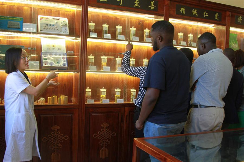 Daktari wa China akiwaonyesha wageni aina mbalimbali za dawa za jadi za China kwenye Kituo cha Tiba za Jadi za China (TCM) na Matibabu ya Acupuncture cha Zimbabwe na China mjini Harare, Zimbabwe, Desemba 2, 2024.(Xinhua/Tafara Mugwara)