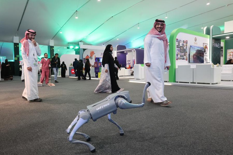 Watu wakitazama burudani ya roboti ya muundo wa mbwa iliyozalishwa na kampuni ya China, Unitree Robotics, kwenye Maonesho ya Mustakabali wa Vyombo vya Habari mjini Riyadh, Saudi Arabia, Februari 20, 2025. (Xinhua/Yin Ke)