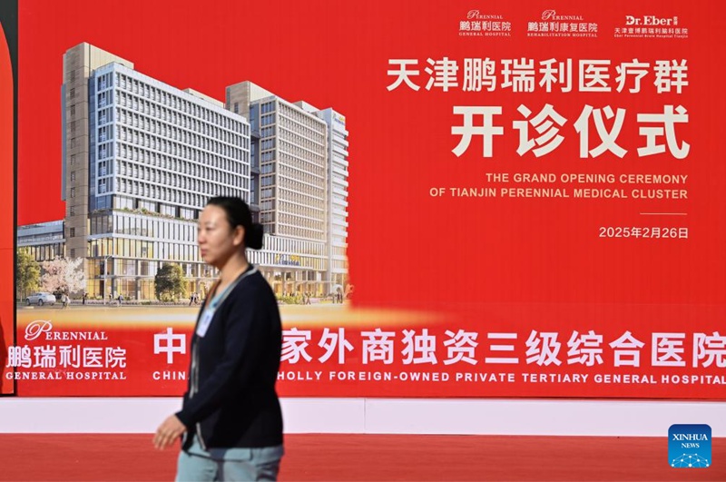 Mhudumu wa afya akitembea kupita bango la tangazo wakati wa uzinduzi wa Hospitali Kuu ya Perennial ya Tianjin ambayo imefunguliwa katika Mji wa Tianjin, kaskazini mwa China, Februari 26, 2025. (Xinhua/Li Ran)