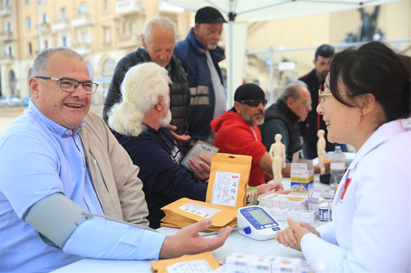 Cao Ying (wa kwanza, kulia), daktari wa Kundi la 20 la timu ya madaktari wa China nchini Malta akitoa huduma ya ushauri wa kiafya kwa wakaazi wenyeji mjini Cospicua, Malta, Machi 9, 2025. (Xinhua/Chen Wenxian)