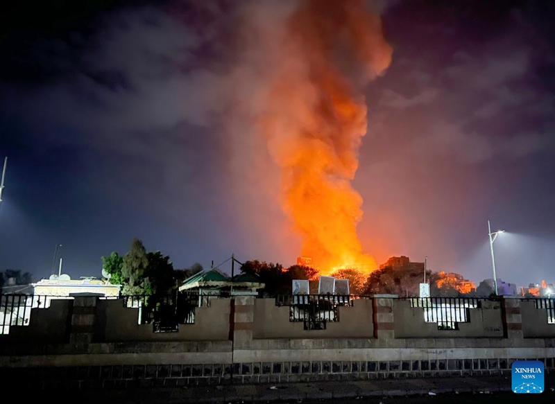Picha iliyopigwa kwa simu janja Machi 19, 2025 ikionyesha moshi na moto vikifuka kutoka kwenye eneo la makazi kufuatia shambulizi la anga mjini Sanaa, Yemen. (Str/Xinhua)