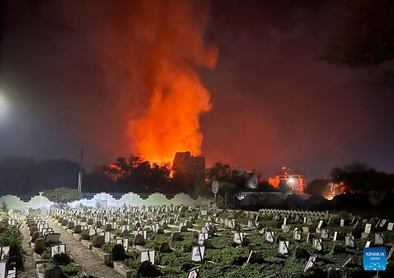 Picha iliyopigwa kwa simu janja Machi 19, 2025 ikionyesha moshi na moto vikifuka kutoka kwenye eneo la makazi kufuatia shambulizi la anga mjini Sanaa, Yemen. (Str/Xinhua)