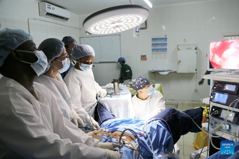 Yang Qing (wa pili, kushoto), mkurugenzi wa Idara ya Uzazi na Magonjwa ya Wanawake katika Hospitali ya Shengjing ya Chuo Kikuu cha Tiba cha China, Cai Guiyang (wa kwanza, kulia), mwanafunzi wa udaktari wa Yang na kiongozi wa kundi la 22 la timu ya madaktari wa China nchini Gambia, pamoja na Kebba Gassama (wa kwanza, kushoto), daktari wa uzazi katika Hospitali Ndogo ya Mafunzo ya Edward Francis na Mariama Baye, muuguzi (wa tatu, kushoto, mbele), wakifanya upasuaji walaparoscopic mjini Banjul, Gambia, Machi 17, 2025. (Xinhua/Si Yuan)
