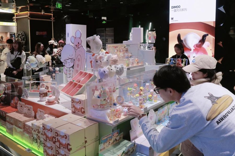 Wateja wakichagua maboksi yenye vitu visivyoonekana kwenye duka la Pop Mart lililopo jengo kubwa la maduka mengi la Joy City katika Mtaa wa Xidan mjini Beijing, Desemba 28, 2024. (Xinhua/Shi Yifei) 