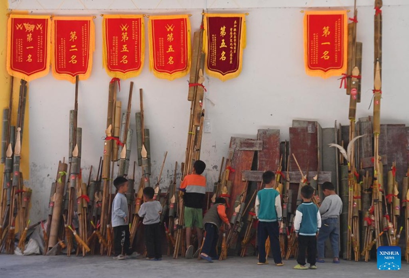 Watoto wakipiga Lusheng, ala ya kijadi ya kupuliza ya mwanzi, katika Kijiji cha Wuying kwenye mpaka kati ya Mkoa unaojiendesha wa Kabila la Wazhuang wa Guangxi, kusini mwa China na Mkoa wa Guizhou, kusini-magharibi mwa China, Oktoba 5, 2024. (Xinhua/Huang Xiaobang)