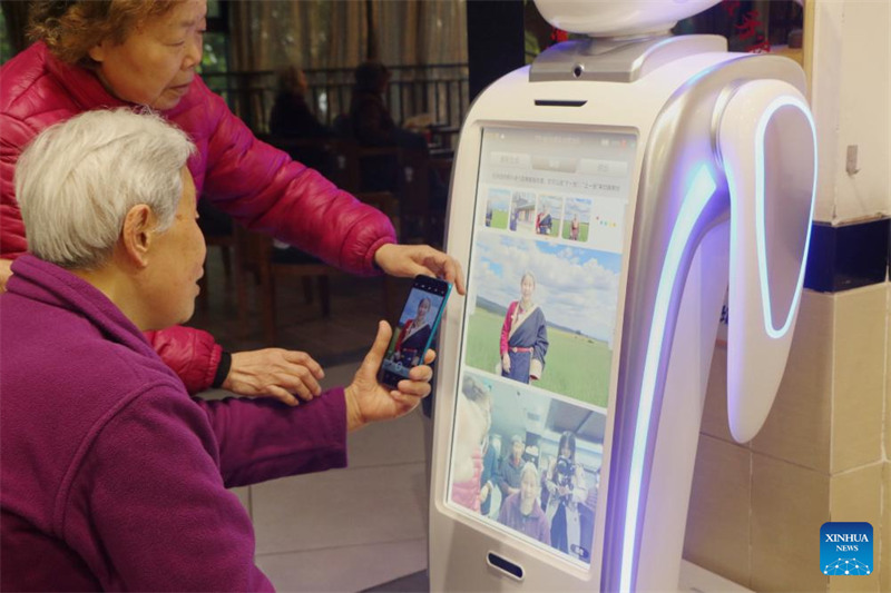 Wazee wa Nyumba ya Kwanza ya Huduma ya Jamii ya Chongqing wakiwasiliana na roboti ya kutunza wazee Peipei katika Mji wa Chongqing, kusini-magharibi mwa China, Machi 28, 2025. (Picha na Zhang Ya/Xinhua)