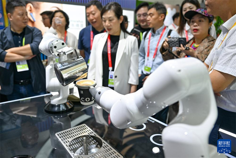 Watembeleaji wakitazama roboti ya kutengeneza cafe kwenye Maonyesho ya 5 ya Kimataifa ya Bidhaa za Matumizi ya China, Mkoani Hainan, Tarehe 13, Aprili.