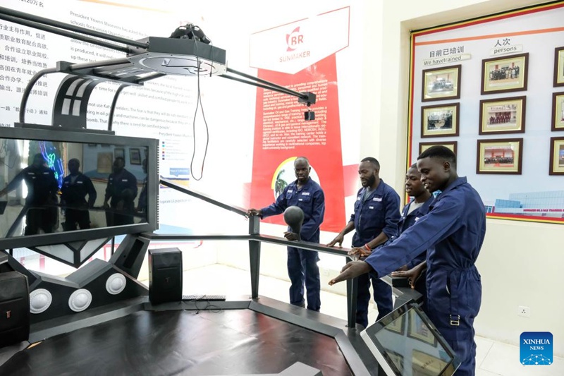 Washiriki mafunzo wakiangalia mashine wakati wa hafla ya ufunguzi wa programu ya kienyeji ya mafunzo ya ujuzi kwa wafanyakazi ya kampuni tanzu ya SINOPEC-Uganda kwenye Taasisi ya Mafunzo ya Mafuta na Gesi ya Sunmaker mjini Kampala, Uganda, Aprili 23, 2025. (Hajarah Nalwadda/Xinhua)