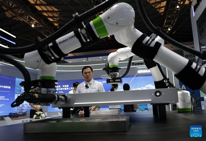 Mfanyakazi akiangalia roboti za kufanya kazi kwa kushirikiana zikionyesha jinsi ya kuunganisha pakiti za betri na kukagua uwekaji nyaya kwenye Maonyesho ya 11 ya Teknolojia ya Kimataifa ya Shanghai China yanayofanyika Shanghai, mashariki mwa China, Juni 11, 2025. (Xinhua/Fang Zhe)