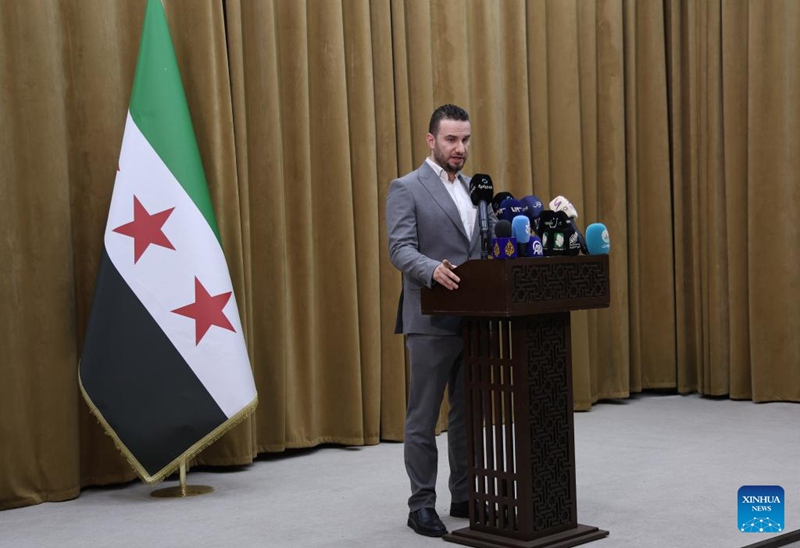 Msemaji wa mamlaka za mambo ya ndani za Syria Noureddin al-Baba (Nyuma) akizungumza kwenye mkutano na waandishi wa habari mjini Damascus, Syria, tarehe 24 Juni 2025. (Picha na Ammar Safarjalani/Xinhua)