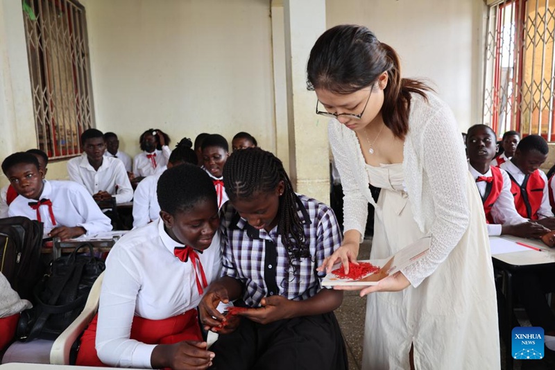 Mwalimu mchina Cai Leqin (katikati) akionyesha kazi ya sanaa ya kukata karatasi ya Kichina kwa wanafunzi katika Shule ya Kimataifa ya Penuel mjini Kasoa katika Mkoa wa Kati, Ghana, Juni 25, 2025. (Xinhua/Seth)