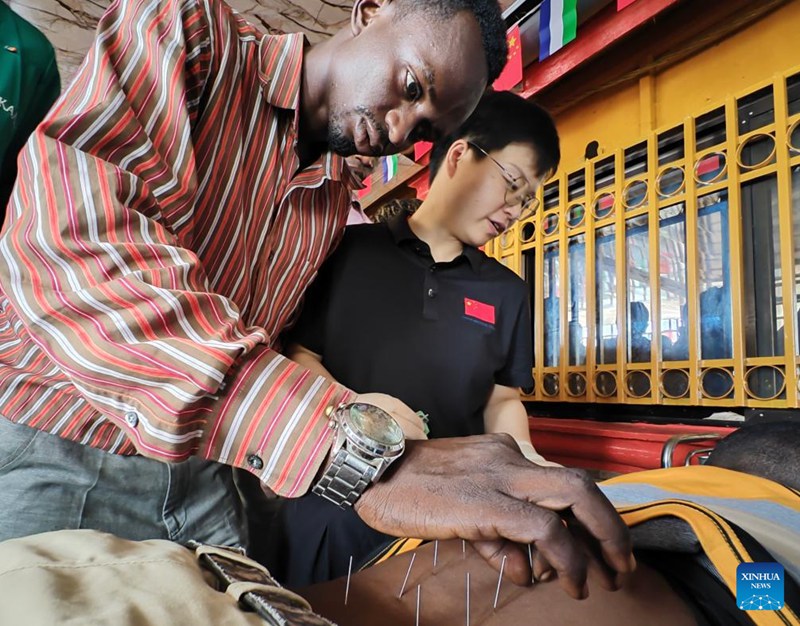 Mwanafunzi (kushoto) akifanya mazoezi ya vitendo ya tiba ya acupuncture chini ya mwongozo wa mtaalamu kutoka timu ya madaktari wa China wakati wa kozi ya mafunzo juu ya mbinu za dawa za jadi za China (TCM) mjini Freetown, Sierra Leone, Juni 27, 2025. (Kundi la 26 la timu ya madaktari wa China nchini Sierra Leone/kupitia Xinhua)