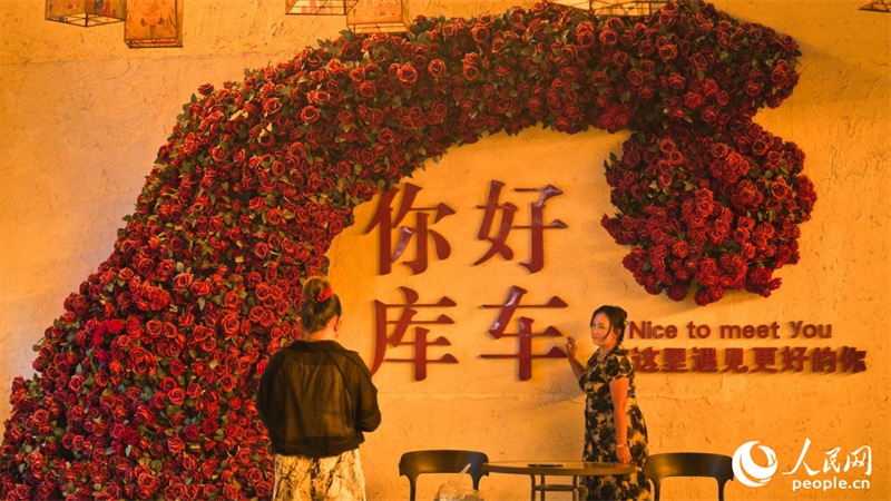 Mtalii akipiga picha kwenye kichochoro cha mji mkongwe wa Kuqa. (Li Xinyang/People’s Daily Online)