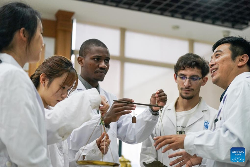 Pan Yinxing (wa kwanza, kulia), mhadhiri kutoka Chuo Kikuu cha Matibabu ya Jadi na Dawa za China cha Anhui, akifundisha wanafunzi wa kimataifa kutumia kipimo cha mizani  huko Hefei, Mkoa wa Anhui, mashariki mwa China, Oktoba 16, 2025. (Xinhua/Du Yu)