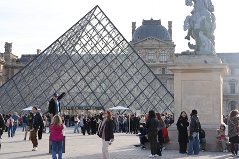 Watalii wakionekana mbele ya Piramidi ya Jumba la Makumbusho la Louvre mjini Paris, Ufaransa, Oktoba 22, 2025. (Xinhua/Zhang Baihui)