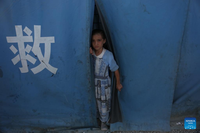 Mtoto akionekana kutoka kwenye hema la msaada uliotolewa na China mjini Kabul, Afghanistan, Novemba 23, 2025. (Picha na Saifurahman Safi/Xinhua)