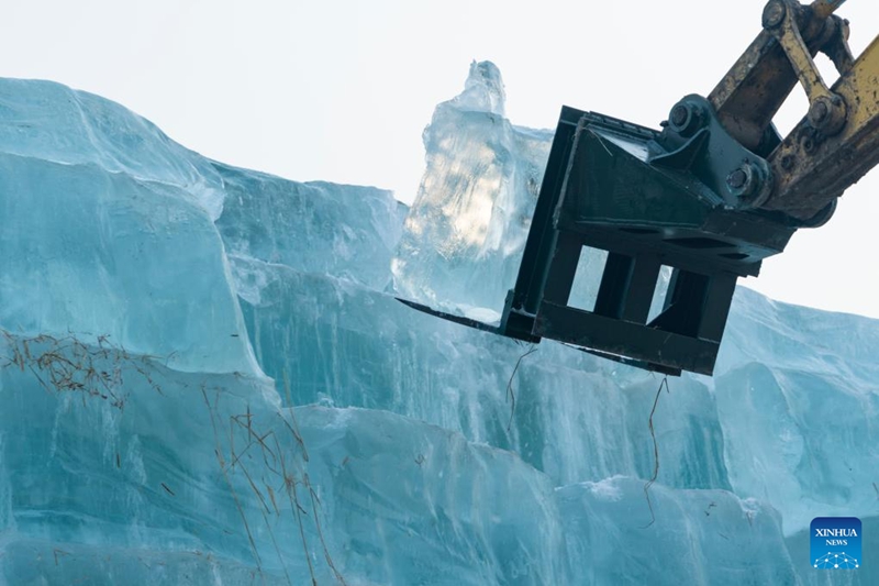 Mashine ikibeba michemiraba ya barafu kwenye eneo la kuhifadhi barafu kwa ajili ya maandalizi ya ujenzi wa Dunia ya Barafu na Theluji ya Harbin katika Mkoa wa Heilongjiang, kaskazini-mashariki mwa China, Novemba 24, 2025. (Xinhua/Xie Jianfei)