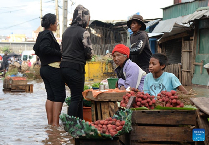 Wachuuzi wakiuza matunda kando ya barabara iliyofurika maji kwenye mtaa mjini Antananarivo, Madagascar, Januari 7, 2026. (Picha na Sitraka Rajaonarison/Xinhua)