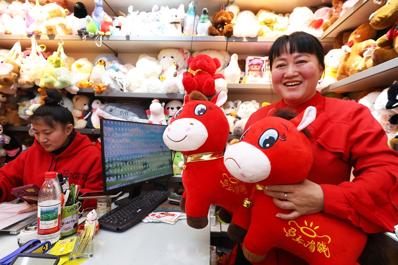 Mfanyakazi akionesha midoli laini ya farasi iliyoshonwa kwa makosa ya "Cry-Cry Horse" kwenye duka katika Mji wa Biashara ya Kimataifa wa Yiwu mjini Yiwu, Mkoa wa Zhejiang, mashariki mwa China, Januari 12, 2026. (Picha na Lyu Bin/Xinhua)