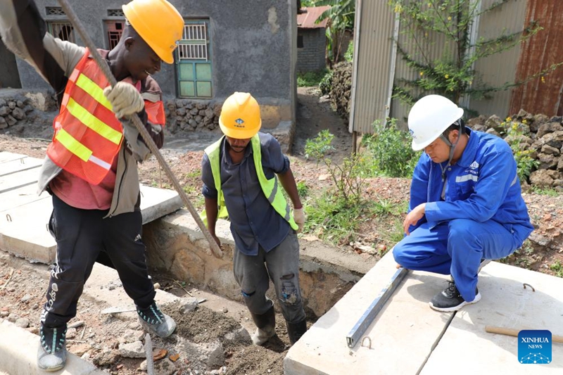 Mhandisi Mchina Zhou Chunyi (kulia) akifanya kazi na wafanyakazi wenzake wenyeji kando ya barabara iliyojengwa na Kampuni ya Barabara na Madaraja ya China katika Wilaya ya Burera, Mkoa wa Kaskazini wa Rwanda, Januari 21, 2026. (Xinhua/Ju Yinhe)