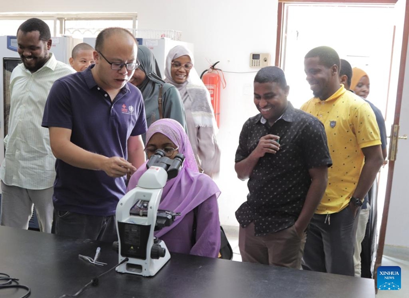 Mtaalamu mchina akionyesha namna ya kufanya uchunguzi wa kichocho kwa kutumia hadubini katika Kisiwa cha Pemba cha Zanzibar, Tanzania, Januari 28, 2026. (Timu ya wataalamu wa mradi wa kuzuia na kudhibiti kichocho Zanzibar unaosaidiwa na China/kupitia Xinhua)