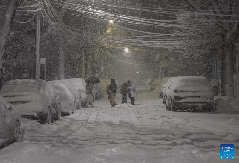 Watu wakitembea kwenye theluji barabarani jijini New York, Marekani, Februari 22, 2026. (Xinhua/Zhang Fengguo)