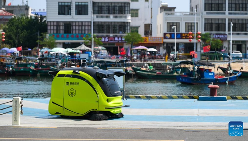 Roboti ya usafi yenye teknolojia za AI ikifanya kazi kwenye Mji mdogo wa Tanmen, Mji wa Qionghai, Mkoa wa Hainan, kusini mwa China, Machi 25, 2026. (Xinhua/Yang Guanyu)