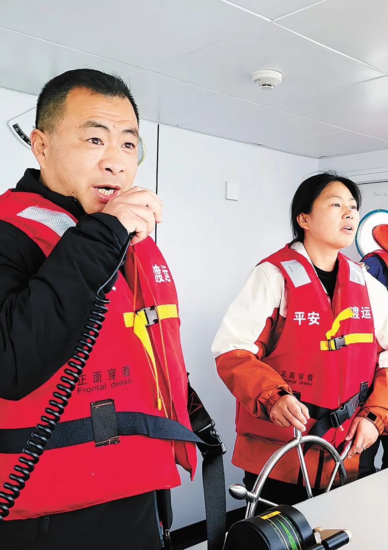 Cao Lifang (kulia) akiendesha feri mpya ya “Yuzhongke 2180”, huku Qin Dayi akitoa tahadhari ya kuwa makini, Machi 31. (Picha na Zhao Jun, People’s Daily)