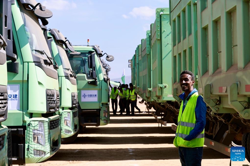 Mfanyakazi akipiga picha na malori yanayotumia umeme ya kubeba mizigo mizito kwenye sehemu ya ujenzi wa Uwanja wa Ndege wa Kimataifa wa Bishoftu, karibu na mji wa Bishoftu katika jimbo la Oromia la Ethiopia, Aprili 29, 2026. (Xinhua/Geng Xinning)