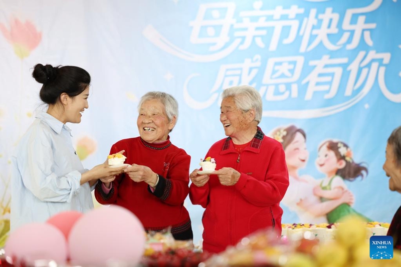 Mfanyakazi akiwaletea wanawake wazee keki kwenye kituo cha huduma ya wazee katika Wilaya ya Tancheng ya Mji wa Linyi, Mkoa wa Shandong, mashariki mwa China, Mei 10, 2026. (Picha na Zhang Chunlei/Xinhua)